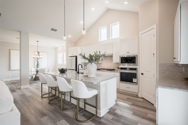 kitchen featuring hardwood / wood-style flooring, stainless steel appliances, a wealth of natural light, and white cabinets