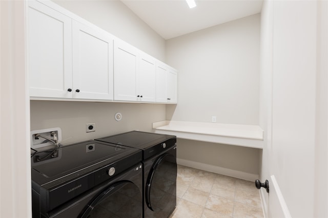 washroom with light tile patterned floors, cabinets, and washing machine and clothes dryer