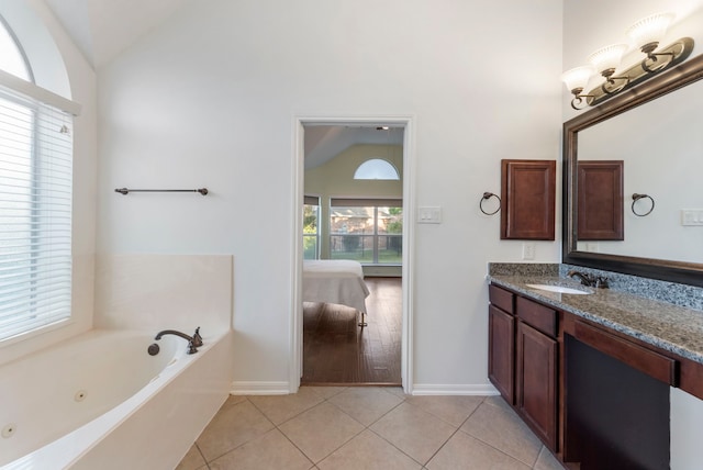 bathroom with vanity, lofted ceiling, a bathtub, and tile patterned flooring