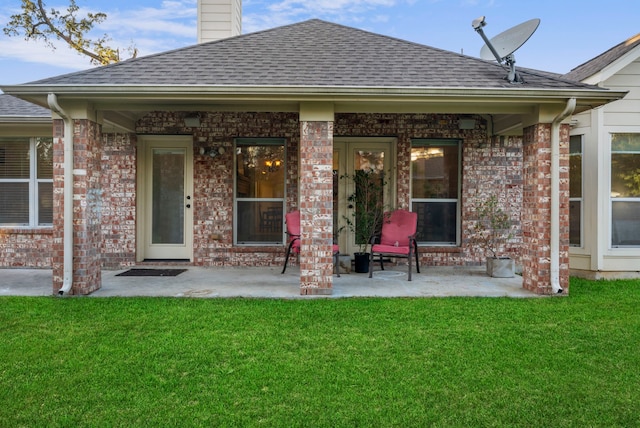 rear view of house featuring a patio and a lawn