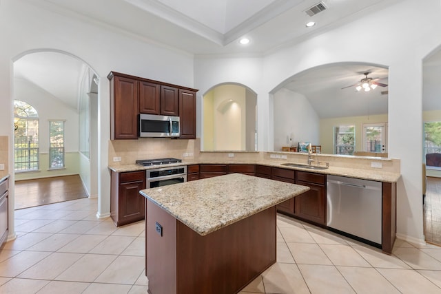 kitchen with appliances with stainless steel finishes, sink, kitchen peninsula, ceiling fan, and light tile patterned floors