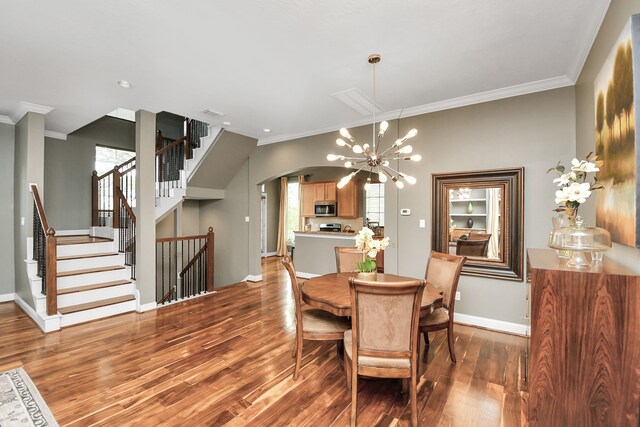 dining room with crown molding, light hardwood / wood-style flooring, and a chandelier