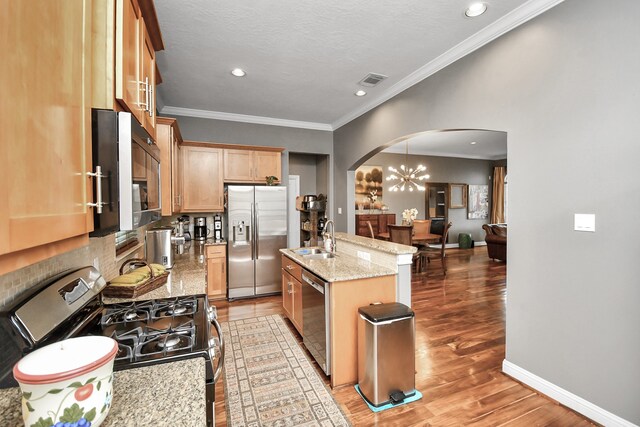 kitchen featuring sink, light stone counters, a center island with sink, appliances with stainless steel finishes, and light hardwood / wood-style floors