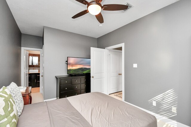 bedroom featuring ceiling fan and ensuite bathroom