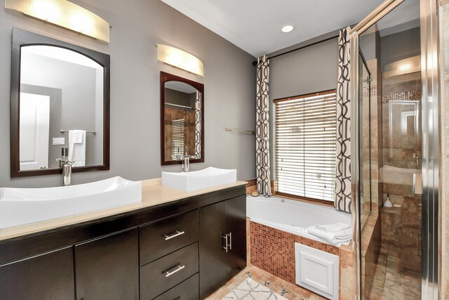 bathroom featuring vanity and separate shower and tub