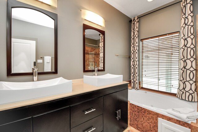 bathroom with vanity and tiled bath