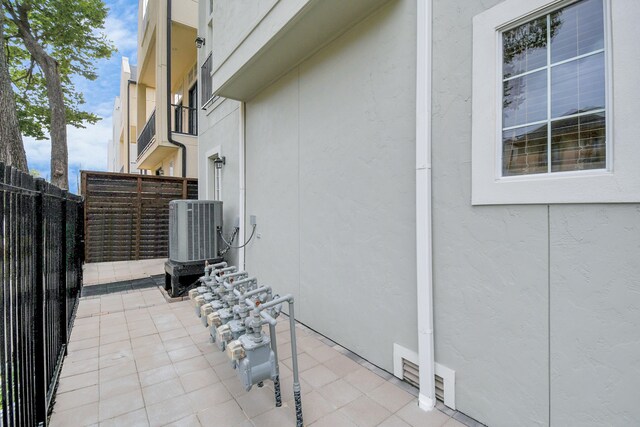 view of side of property with a patio and central AC unit