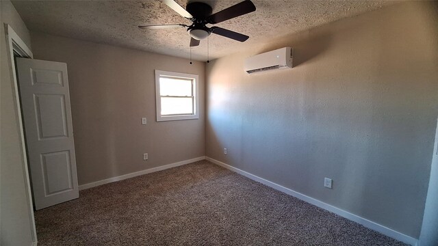 carpeted empty room with an AC wall unit, ceiling fan, and a textured ceiling