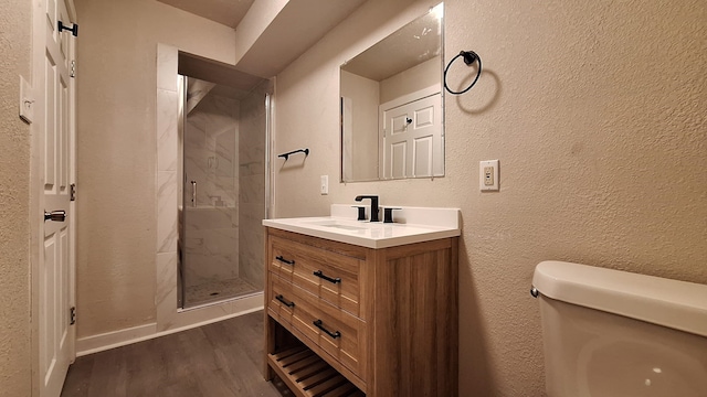 bathroom featuring walk in shower, toilet, vanity, and hardwood / wood-style flooring