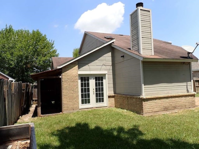 back of house with french doors and a yard