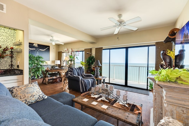 living room featuring a wealth of natural light, hardwood / wood-style floors, and a water view