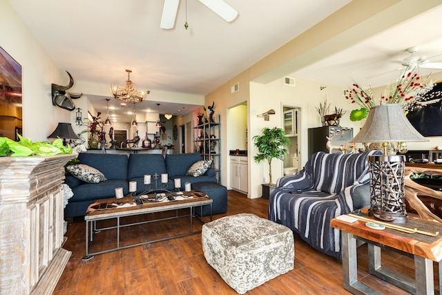 living room with ceiling fan with notable chandelier and dark hardwood / wood-style flooring