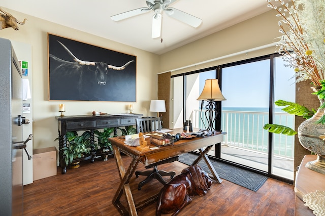 office area with a water view, ceiling fan, dark wood-type flooring, and a wealth of natural light