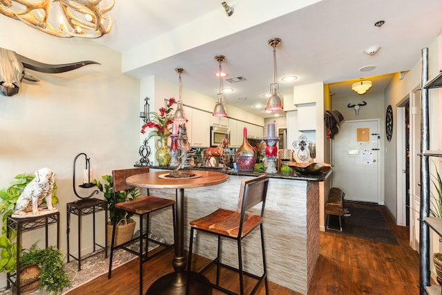 kitchen with white cabinets, dark hardwood / wood-style floors, and oven