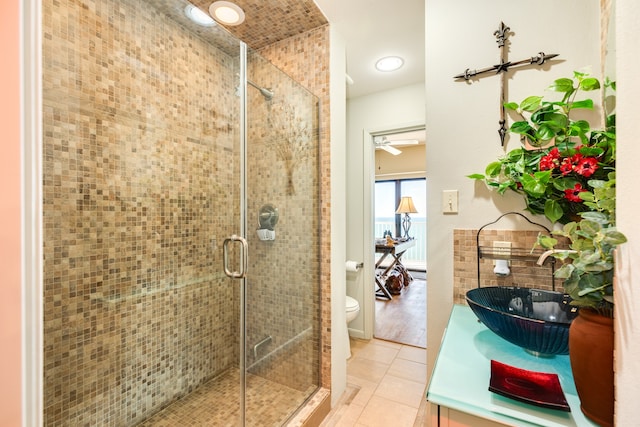 bathroom featuring hardwood / wood-style floors, ceiling fan, toilet, a shower with shower door, and vanity