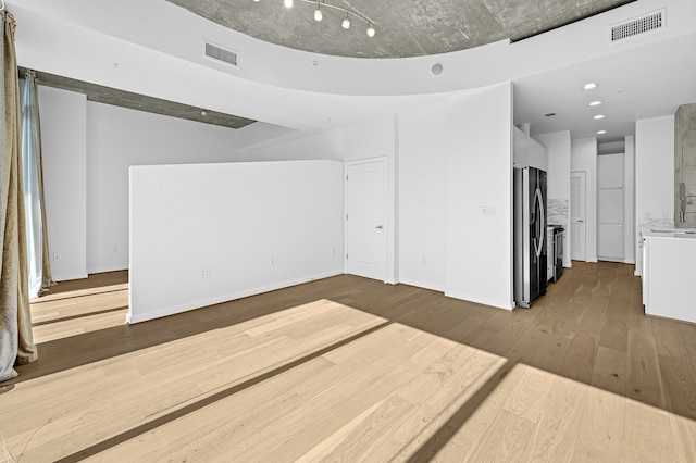 unfurnished living room with wood-type flooring and sink