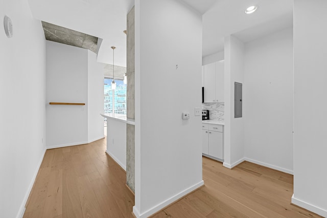 hallway featuring electric panel and light hardwood / wood-style floors