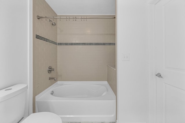 bathroom with toilet and tiled shower / bath