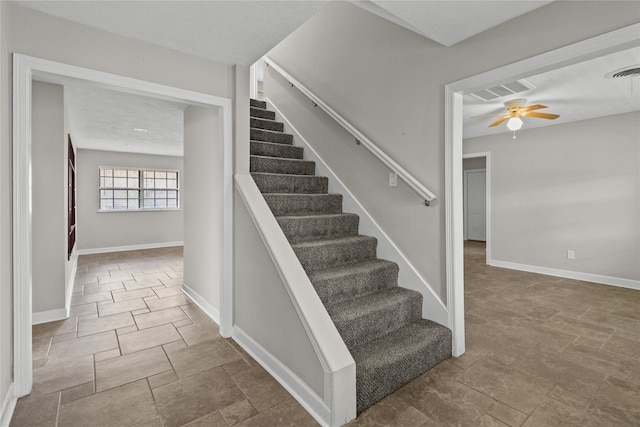 staircase featuring ceiling fan and a textured ceiling