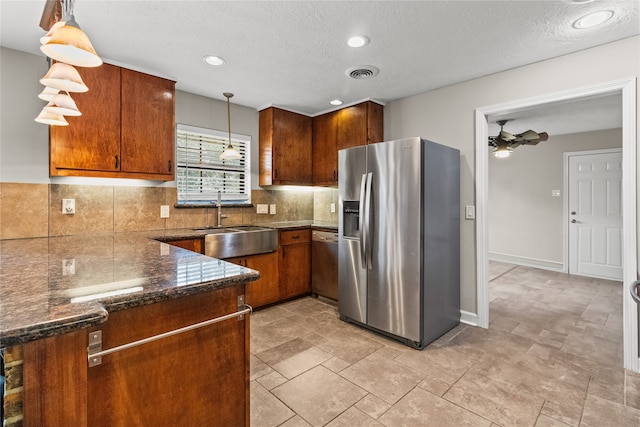 kitchen with tasteful backsplash, stainless steel appliances, decorative light fixtures, sink, and ceiling fan