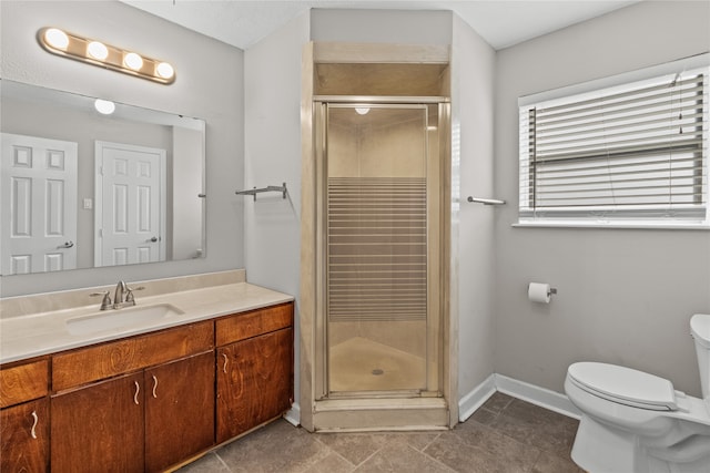 bathroom with toilet, vanity, tile patterned floors, and walk in shower