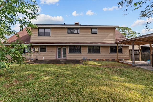 back of house with a patio area and a lawn