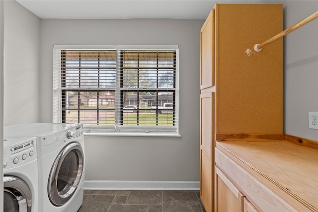 laundry area featuring cabinets, washing machine and clothes dryer, and plenty of natural light