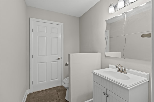 bathroom featuring toilet, vanity, and tile patterned flooring