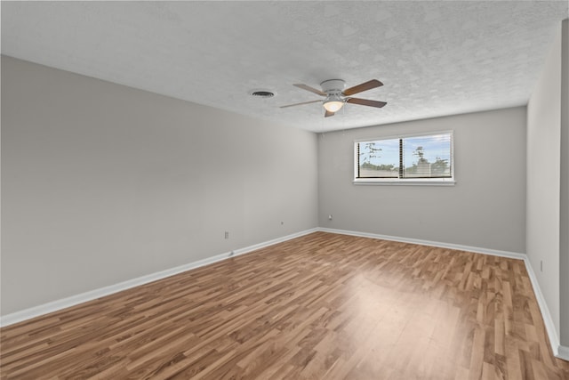 spare room with wood-type flooring, ceiling fan, and a textured ceiling