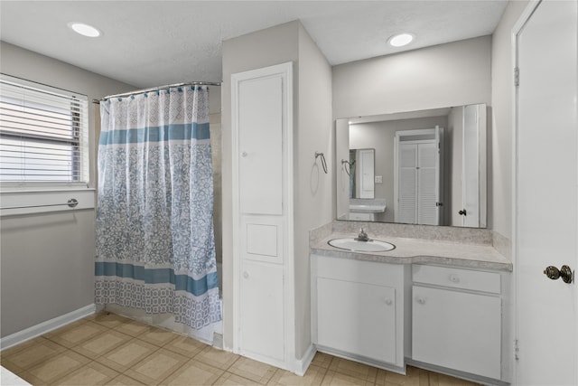 bathroom featuring walk in shower, vanity, and a textured ceiling