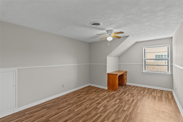 bonus room featuring a textured ceiling, ceiling fan, and light hardwood / wood-style flooring