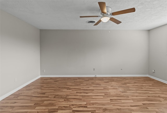 unfurnished room with ceiling fan, a textured ceiling, and light wood-type flooring