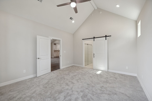 unfurnished bedroom with a barn door, beam ceiling, high vaulted ceiling, carpet, and baseboards