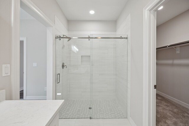 bathroom with vanity, walk in shower, and tile patterned flooring