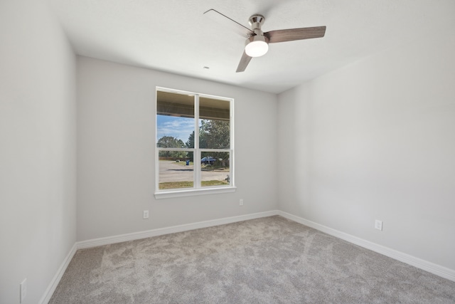 carpeted spare room with baseboards and ceiling fan