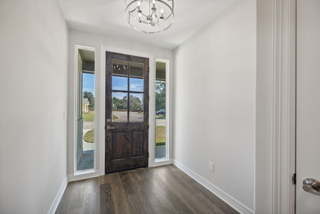 foyer with an inviting chandelier, baseboards, and dark wood finished floors