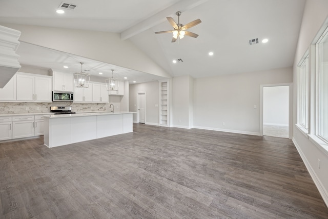 kitchen featuring lofted ceiling with beams, dark hardwood / wood-style flooring, white cabinetry, stainless steel appliances, and a kitchen island with sink