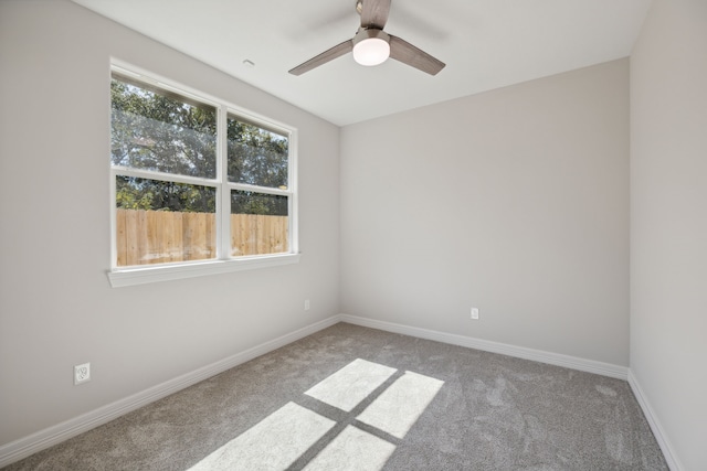 empty room with carpet flooring, ceiling fan, and baseboards