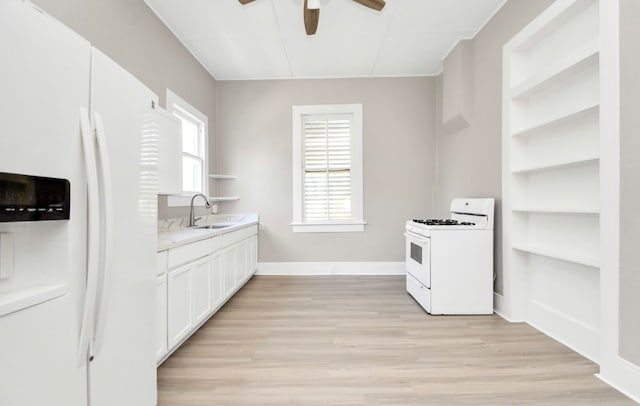 kitchen featuring white appliances, white cabinetry, sink, and light wood-type flooring