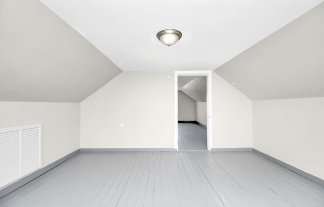 bonus room with vaulted ceiling and light hardwood / wood-style flooring