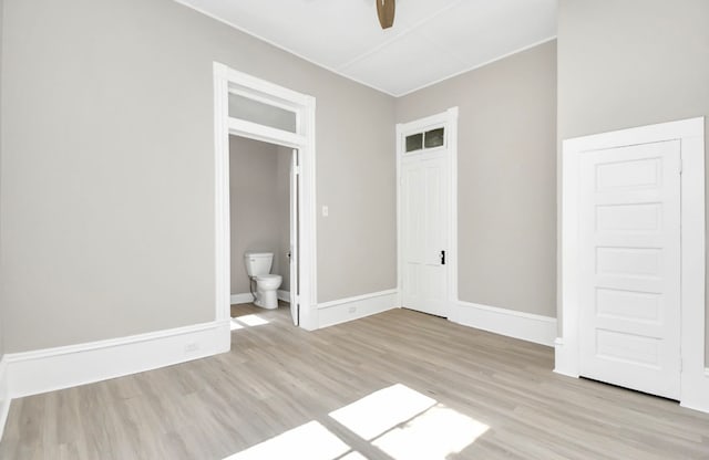 unfurnished bedroom with connected bathroom, ceiling fan, and light wood-type flooring