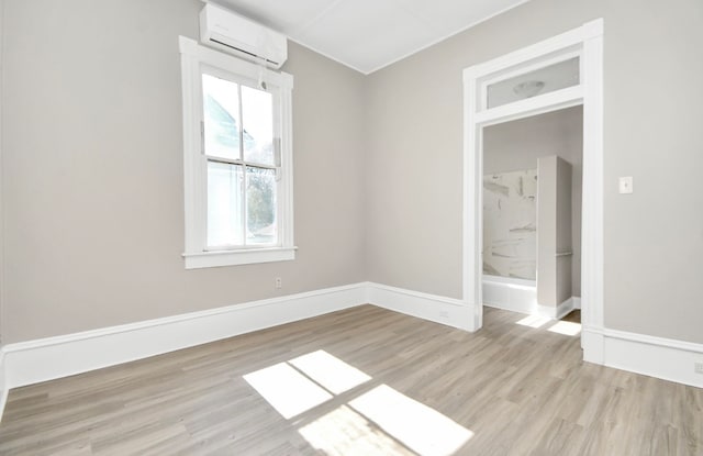 spare room featuring light hardwood / wood-style floors and a wall mounted AC