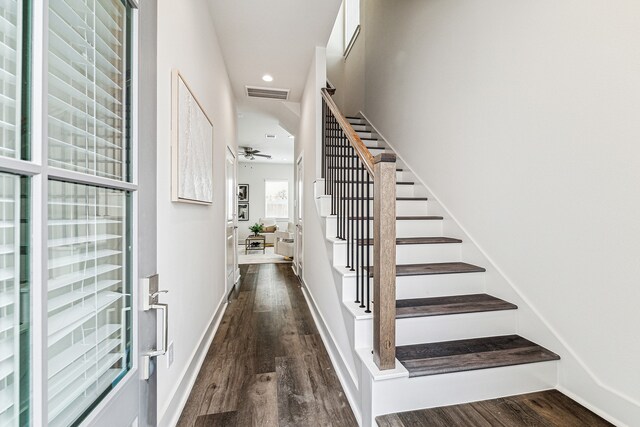 staircase with hardwood / wood-style flooring and ceiling fan