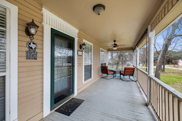 wooden terrace featuring a porch and ceiling fan