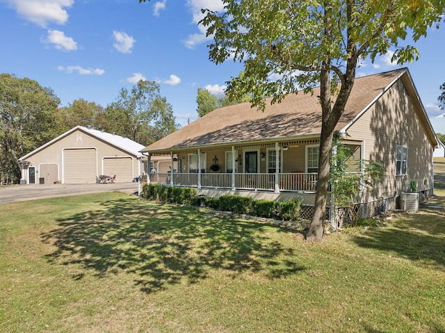 view of front of house with a porch, a front yard, an outbuilding, and a garage