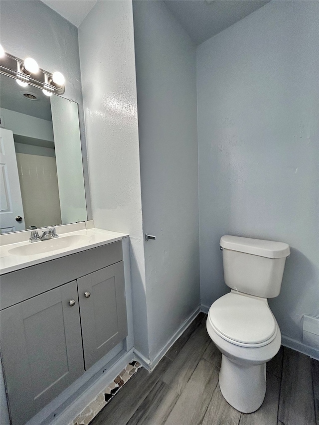 bathroom featuring vanity, toilet, and hardwood / wood-style flooring