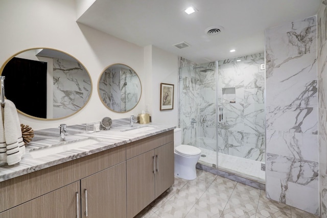 full bathroom featuring a sink, double vanity, visible vents, a marble finish shower, and toilet