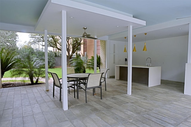 view of patio / terrace with ceiling fan, outdoor dining space, and a sink