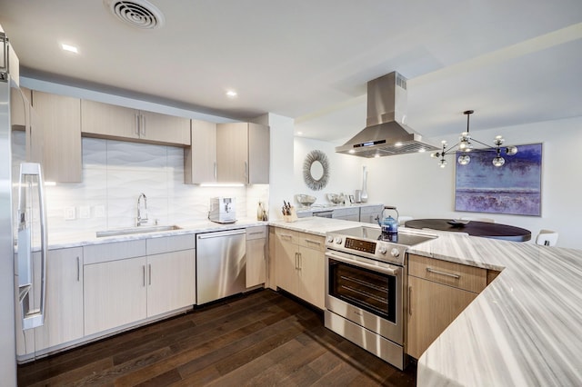 kitchen with a sink, appliances with stainless steel finishes, dark wood-style floors, exhaust hood, and a peninsula