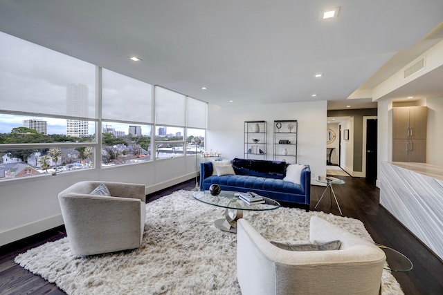 living room featuring a view of city, visible vents, baseboards, recessed lighting, and wood finished floors